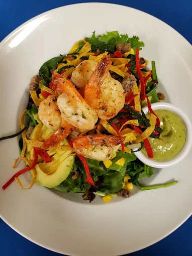Fusion garden salad topped with shrimp and avocado